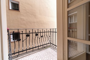 A balcony with a metal railing, a tiled floor, and a beige wall. - Spacious 3BR, 2-Bath Ground-Floor Apartment in Central Istanbul (İstanbul)