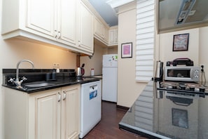 A kitchen with white cabinets, a black countertop, a dishwasher, a refrigerator, a microwave, and a stove. - Spacious 3BR, 2-Bath Ground-Floor Apartment in Central Istanbul (İstanbul)