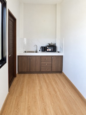 A compact kitchen with a sink, a stove, and a cabinet.