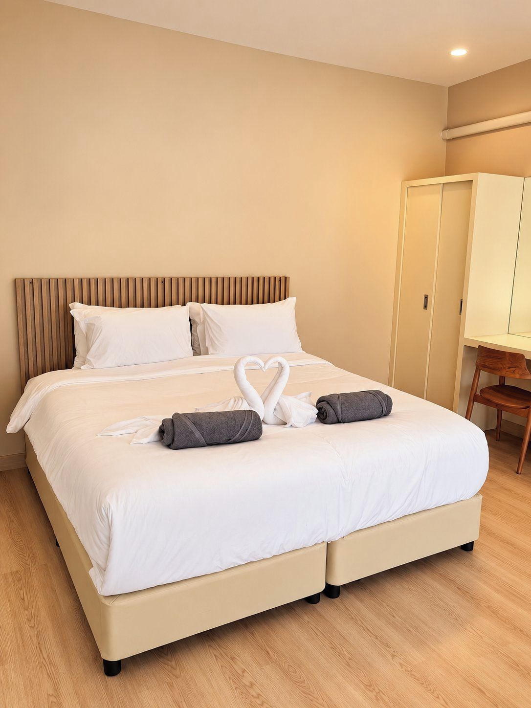A hotel room with a bed, a wardrobe, and a desk.