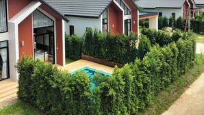 A row of modern houses with a swimming pool in the foreground. - Luang Lume Pool (Chiang Dao)