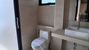 A modern bathroom with a toilet, sink, and shower. - Luang Lume Pool (Chiang Dao)