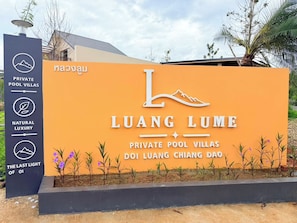 A sign for Luang Lume Private Pool Villas with a mountain icon, indicating a natural setting.