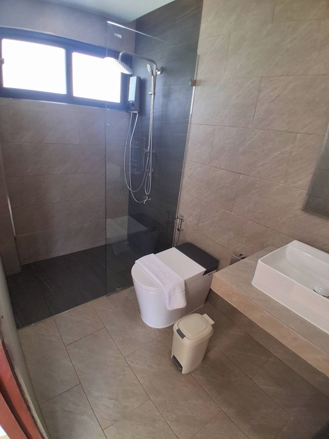 Un baño moderno con ducha de vidrio, inodoro y bañera.