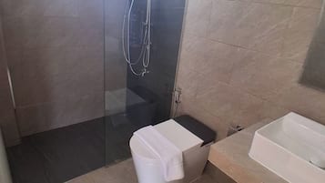 Un baño moderno con ducha de vidrio, inodoro y bañera.