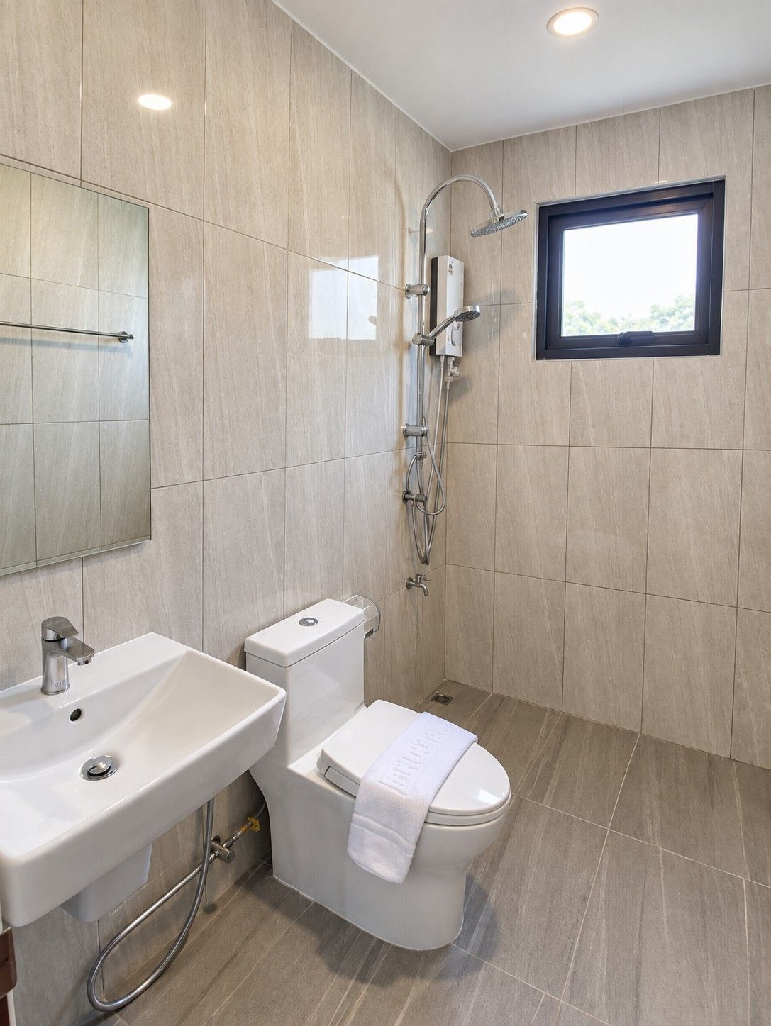 A modern bathroom with a toilet, sink, and shower.