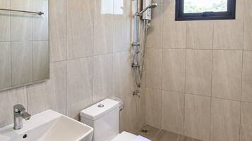 A modern bathroom with a toilet, sink, and shower.