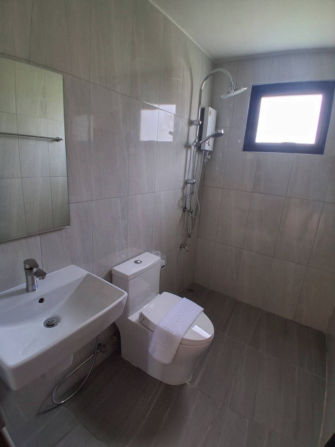 Un baño con lavamanos, inodoro y ducha.