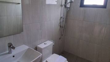 Un baño con lavamanos, inodoro y ducha.