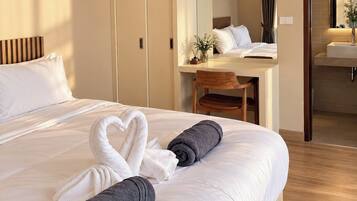 A hotel room with a bed, a desk, a wardrobe, and a bathroom.