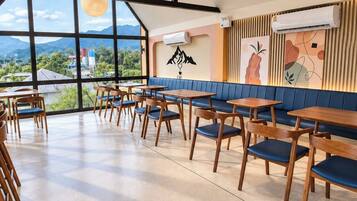 A spacious dining area with high ceilings, large windows, and a view of the mountains.