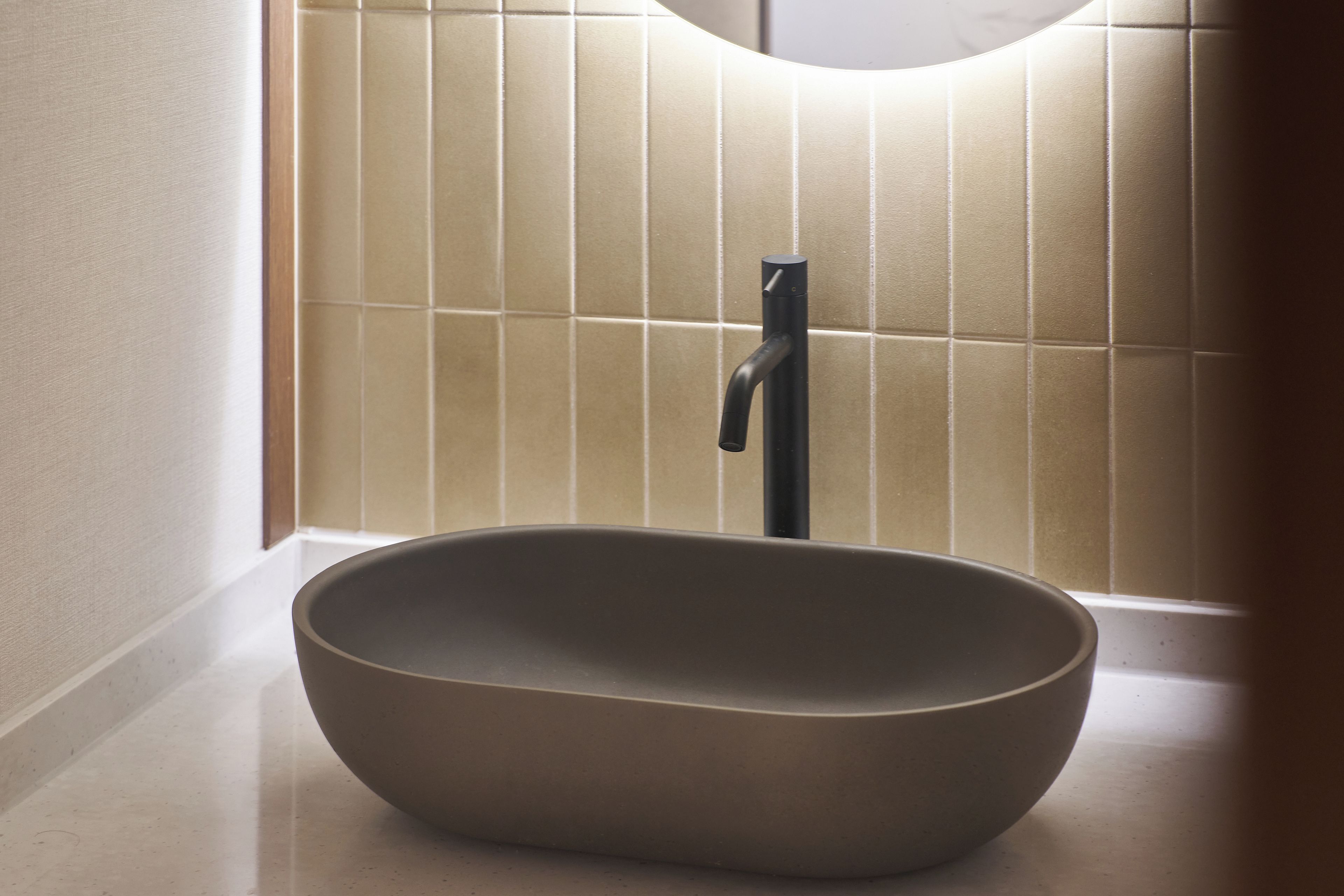 Un baño moderno con un lavabo sobre encimera y un grifo empotrado.