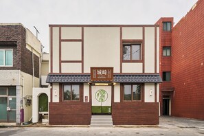 A two-story building with a sign indicating it is a hotel. There are two visible windows on the ground floor, and a door with a green awning. - Stay Passport Kinosaki Ryokan Daejeon Yucheon by Anuk (Daejeon)