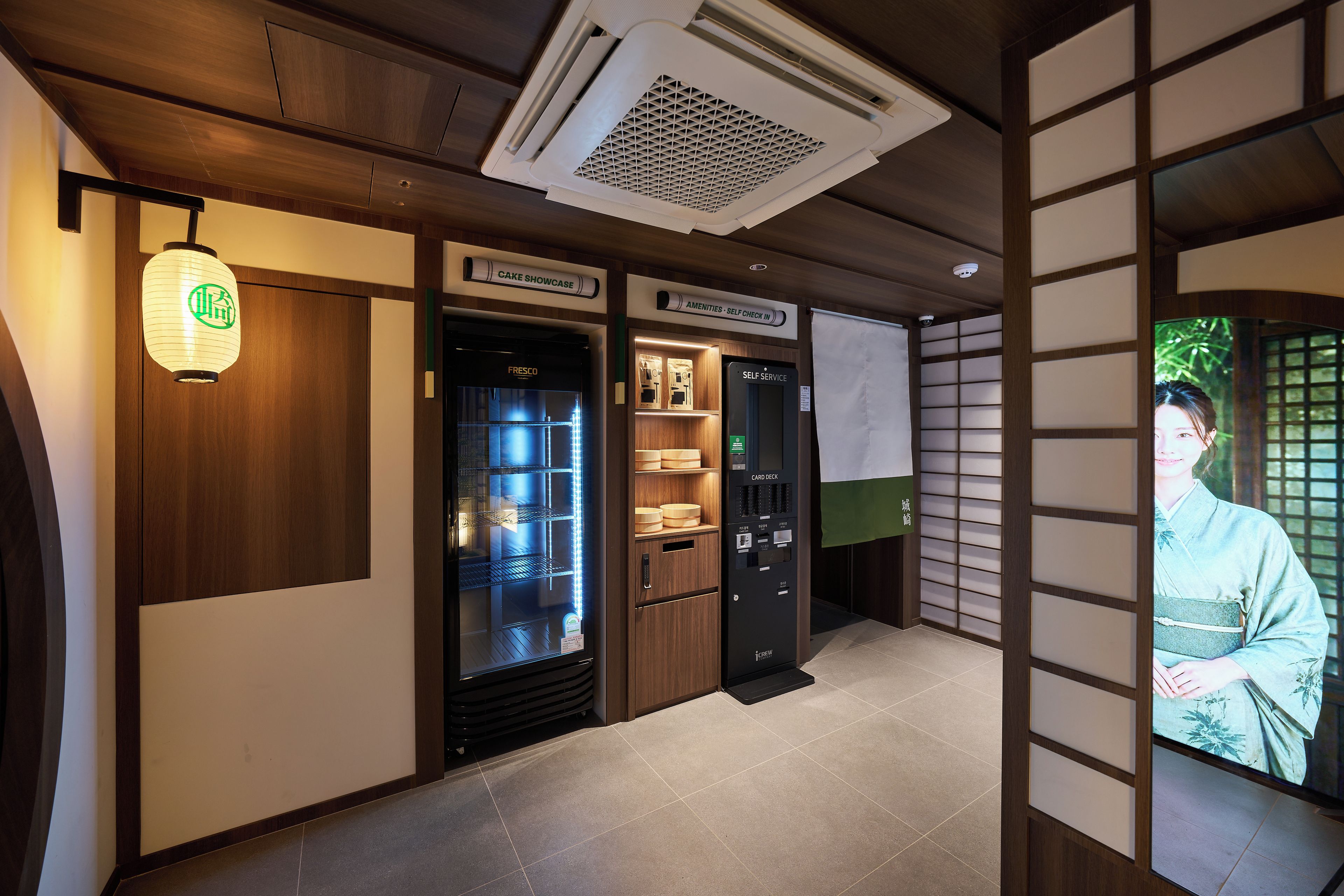 Habitación de hotel con minibar, una baraja de cartas de autoservicio y una vitrina para pasteles.