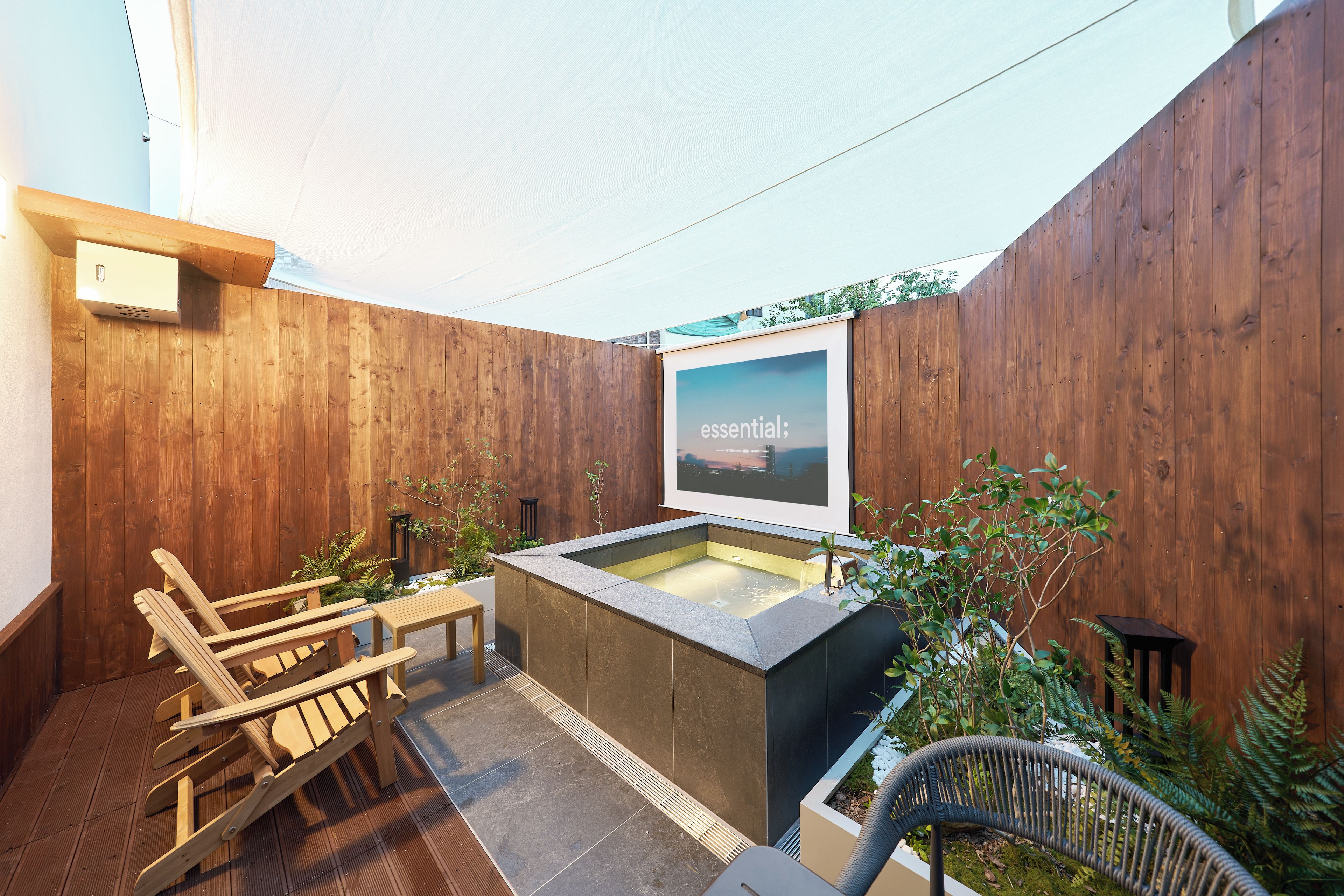 A wooden deck with outdoor seating and a hot tub.