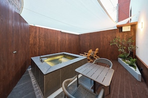 A wooden deck with a hot tub, a table, and chairs. - Stay Passport Kinosaki Ryokan Daejeon Yucheon by Anuk (Daejeon)