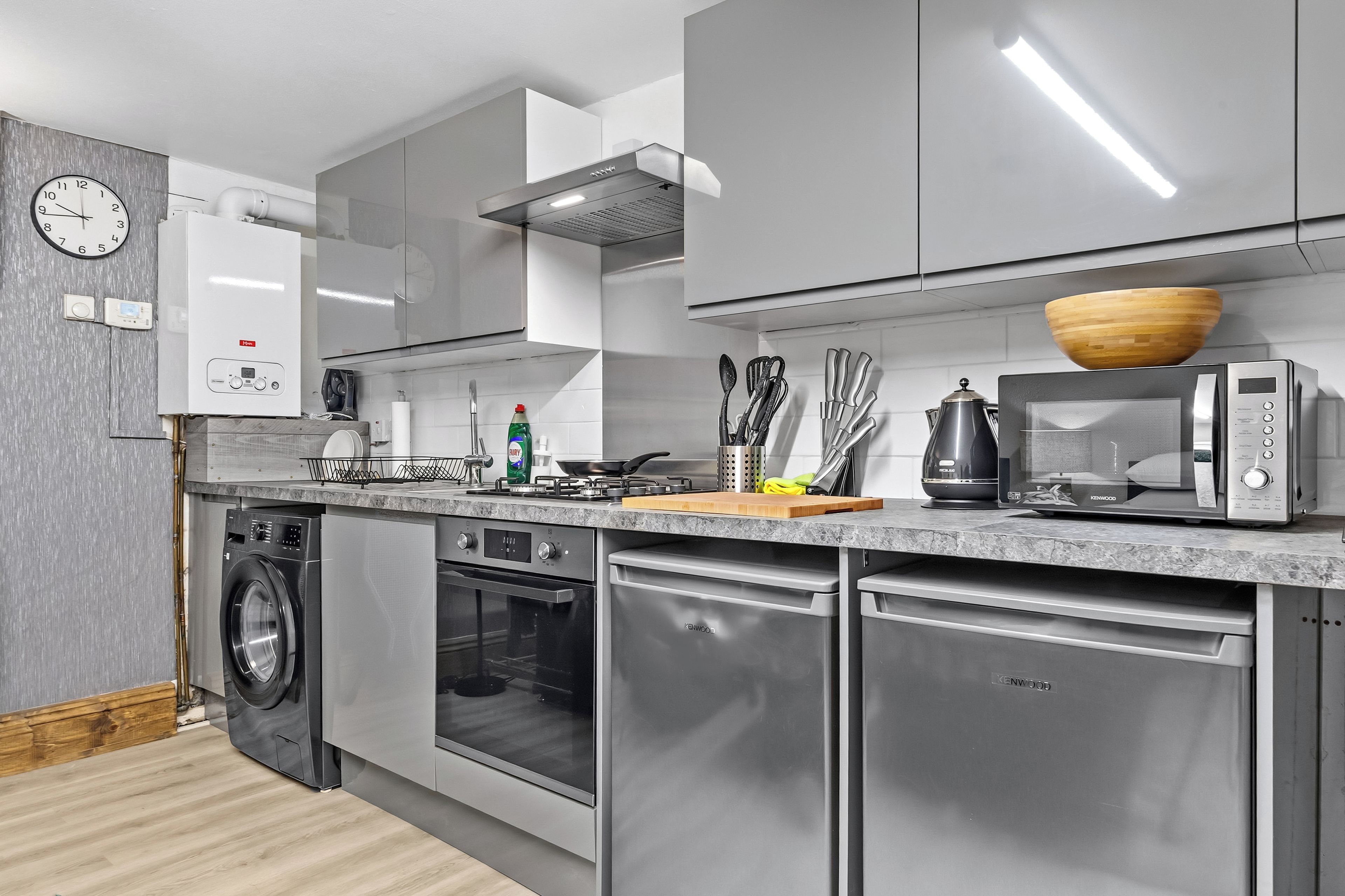 Una cocina moderna con electrodomésticos de acero inoxidable, horno empotrado y microondas.