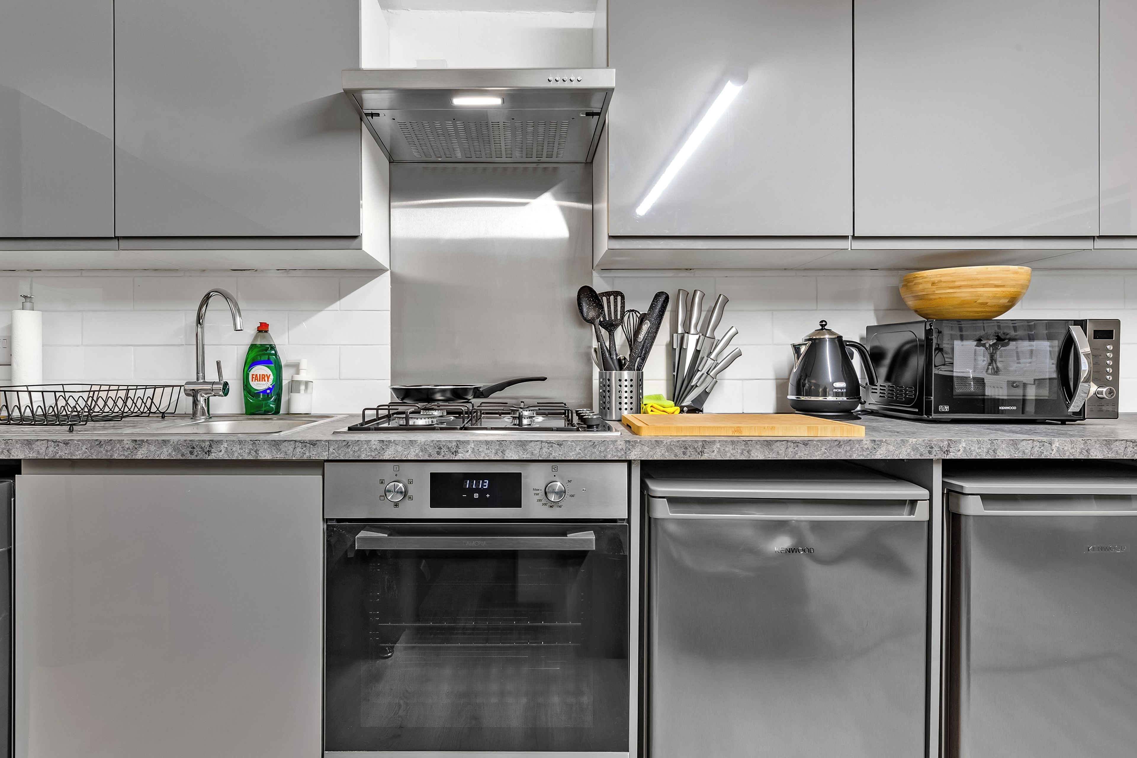 A modern kitchen with stainless steel appliances, a gas stove, a dishwasher, and a microwave.