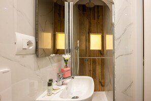 A bathroom with a white sink, a mirror, and a shower area. - Casa Torta by Maison Florence (Florence)