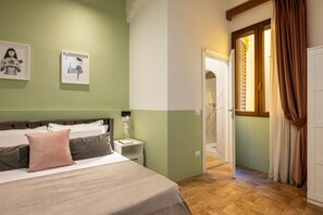 Ein Schlafzimmer mit einem Bett, Nachttisch und einem Kunstwerk an der Wand.