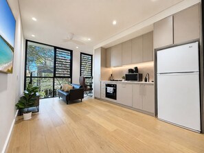 Una cocina moderna con microondas, horno y refrigerador integrados.