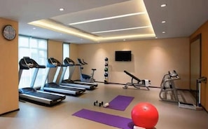 A gym with treadmills, a stationary bike, and exercise mats. - Echarm Hotel (Chongqing)
