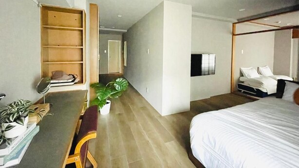 A hotel room with a bed, a desk with a chair, a bookshelf, and a potted plant. - Alphabed Hakata Comfort (Fukuokashi,Hakataku,Hakataekimae)