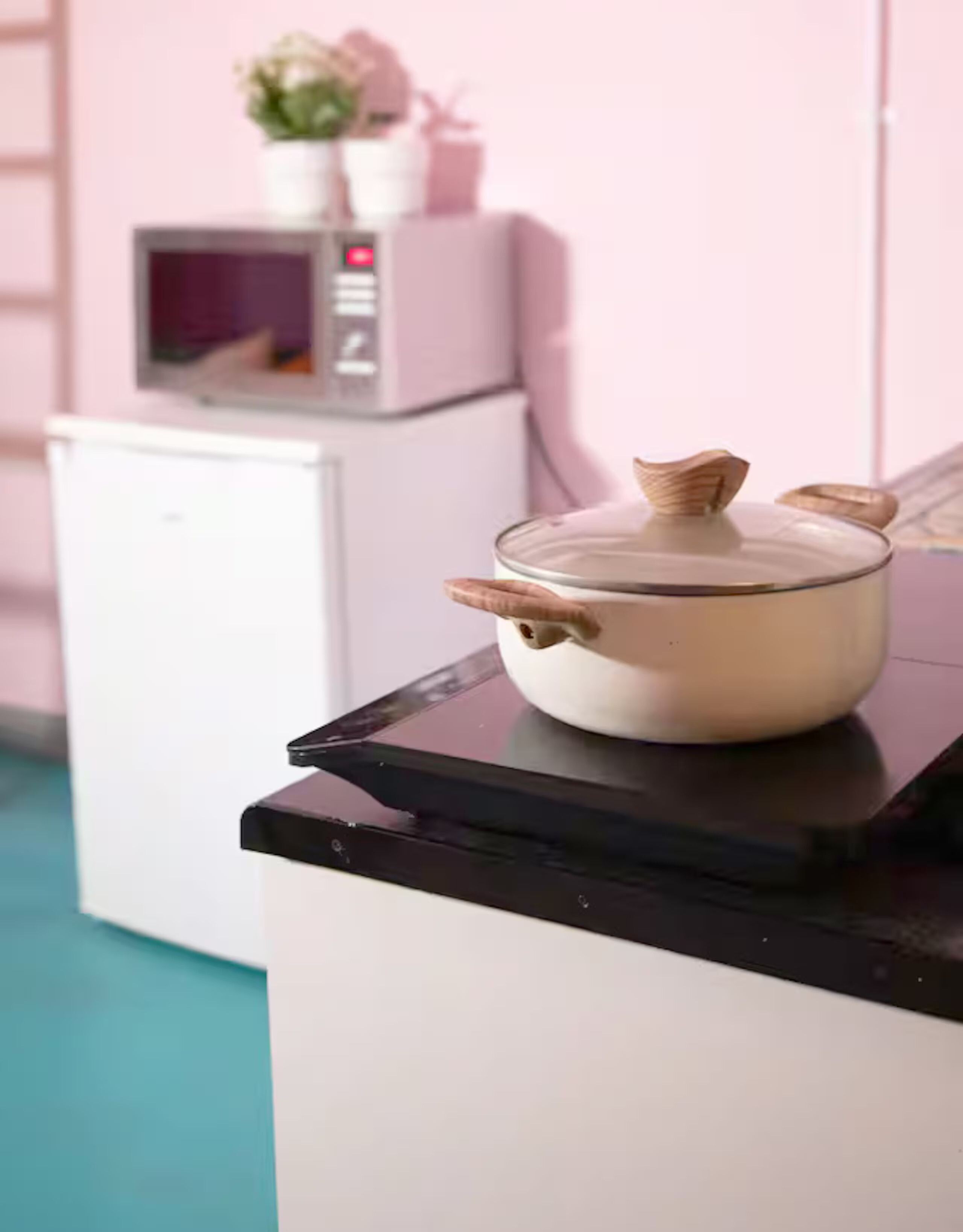 A kitchen counter with a white pot on top.