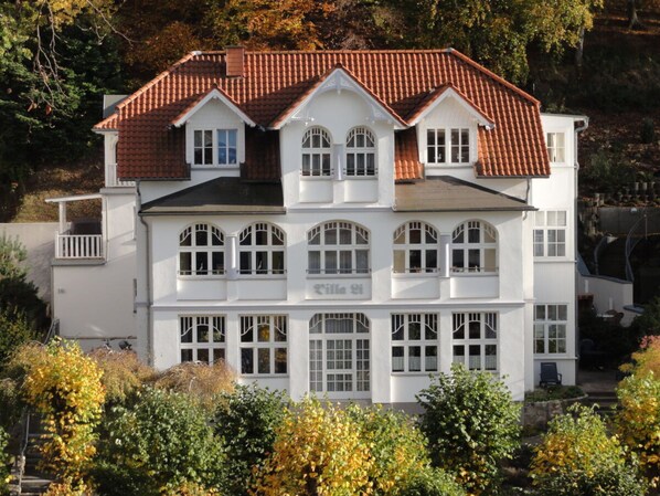 A multi-story building with a symmetrical facade, large windows, and a tiled roof. - Holiday Apartment With 2 Bedrooms (Sellin)