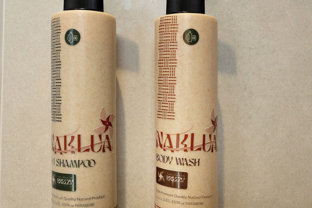 Two bottles of NAKLUNA body wash and shampoo with pump dispensers, placed on a flat surface.