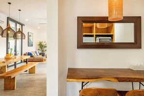 Ein modernes Interieur mit einem Holztisch, Bänken und hängenden Pendelleuchten.
