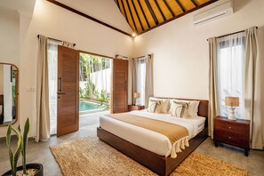 Ein geräumiges Schlafzimmer mit einem großen Bett, einem Holz-Kopfteil und Blick auf einen Swimmingpool.