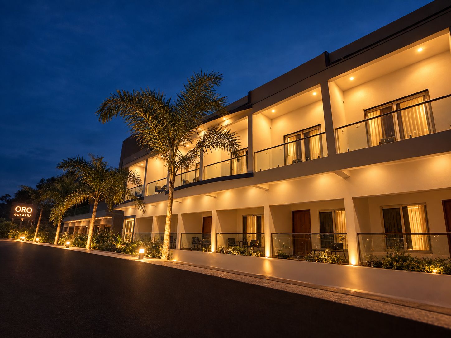 Un hotel de varios pisos con un diseño moderno, con balcones y una fachada bien iluminada.