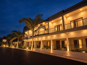 A multi-story hotel with a modern design, featuring balconies and a well-lit facade. - ORO Gokarna (Kumta)