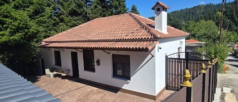 Una propiedad residencial con techo de tejas, patio cercado y cielo despejado.