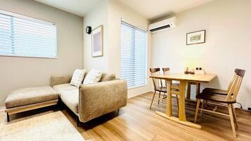A cozy living area with a sofa, a dining table, and chairs.