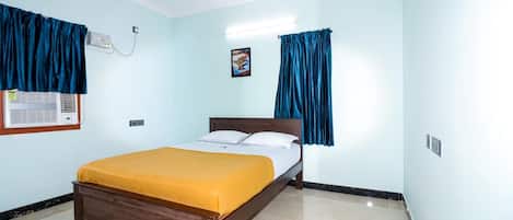 Un dormitorio con cama, ventilador de techo y aire acondicionado de pared.