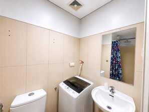 Ein Badezimmer mit Toilette, Waschmaschine und Waschbecken.