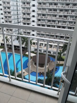 A multi-story residential building with balconies, a swimming pool, and a covered pavilion. - Fancy 1Br Condo Front of MOA IKEA at Shell  ResidencesTower B (Pasay)