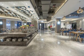 A modern hotel lobby with a marble reception desk, seating areas, and a buffet. - Lavande Hotel (Ganzhou)