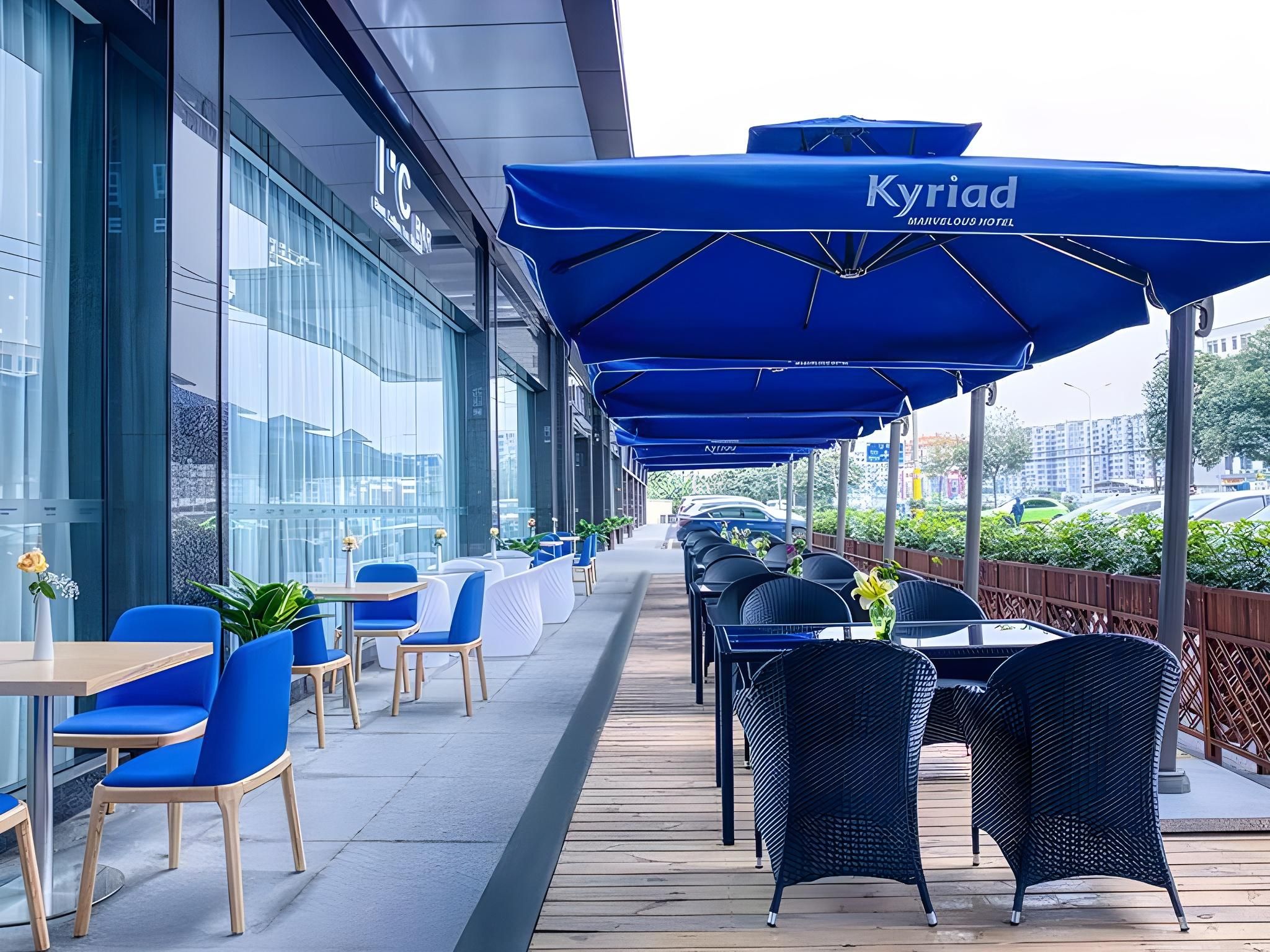 An outdoor seating area with blue umbrellas, tables, and chairs.
