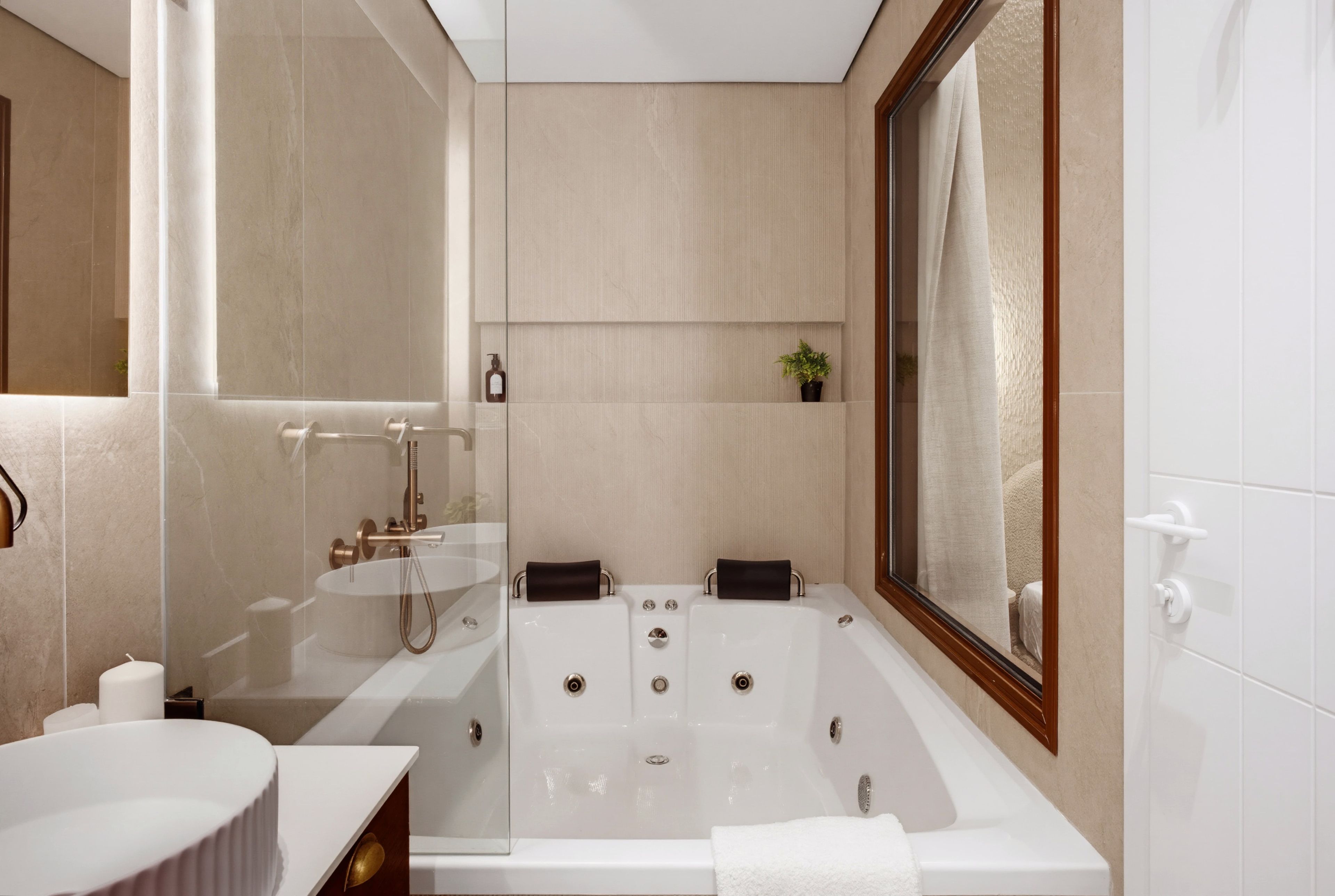 Un baño moderno con una bañera independiente, un tocador con espejo y zona de ducha.
