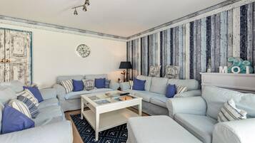 A living room with a sofa set, a coffee table, and a wall clock.