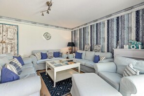 Una sala de estar con un sofá, una mesa de centro y un reloj de pared.