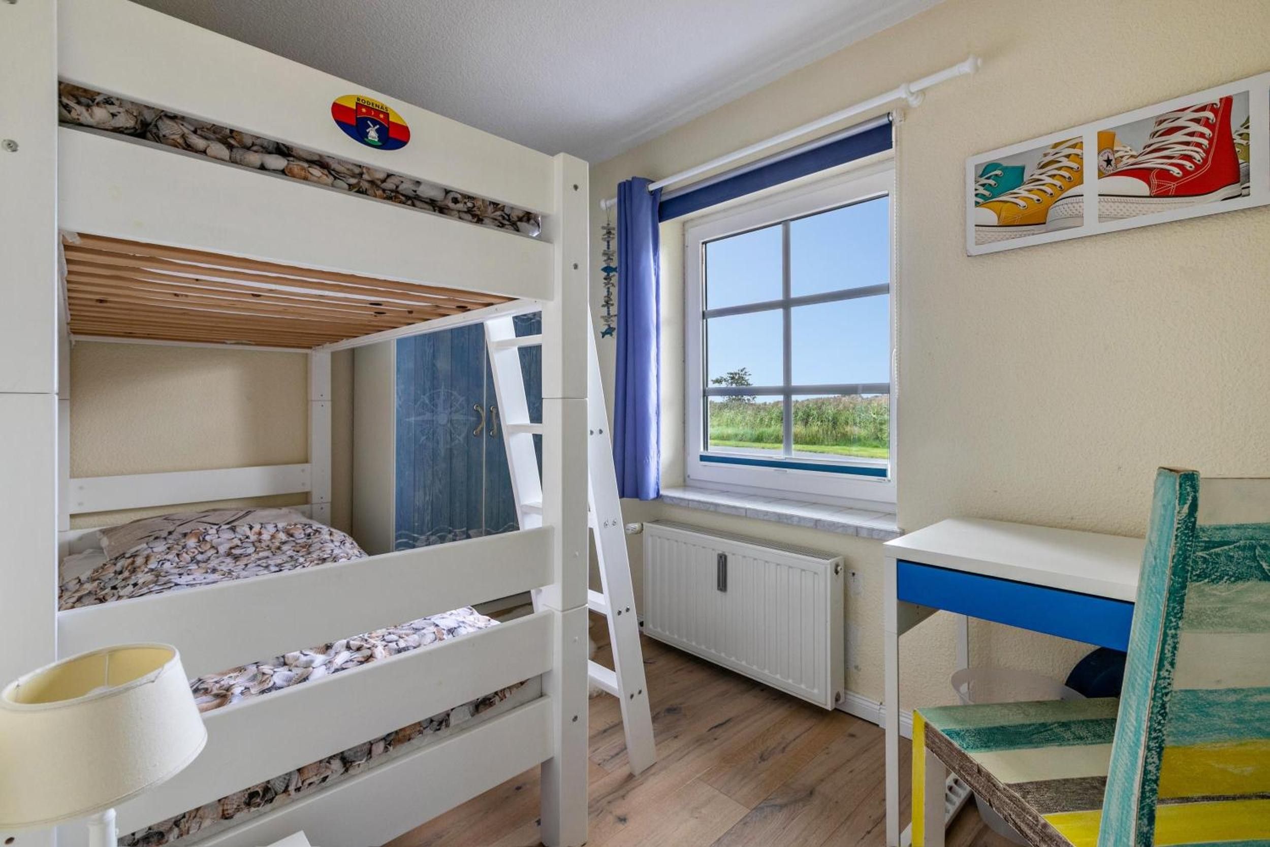 Une chambre avec des lits superposés donnant sur l’extérieur par une fenêtre.