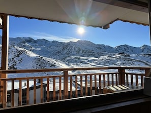 Ein Balkon mit Blick auf schneebedeckte Berge und einen klaren Himmel.