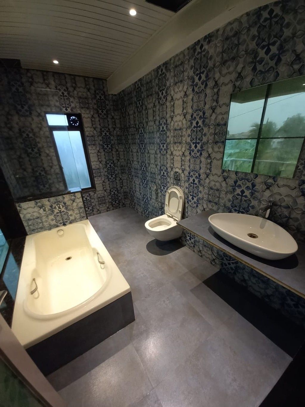 A modern bathroom with a freestanding bathtub, a toilet, and a vanity with a sink.