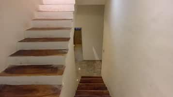 A staircase with alternating white and dark wooden steps leading to a landing.