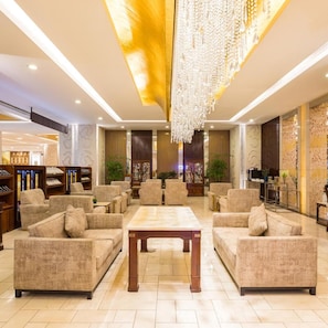 A spacious lobby with a central seating area, bookshelves, and a large chandelier. - West International Trade Hotel (Beijing)