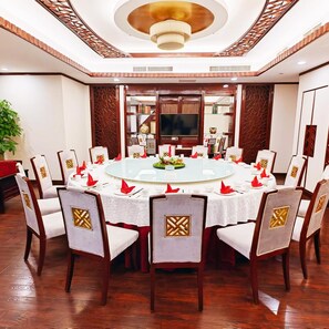A conference room with a round table, white tablecloths, and red napkins. - West International Trade Hotel (Beijing)